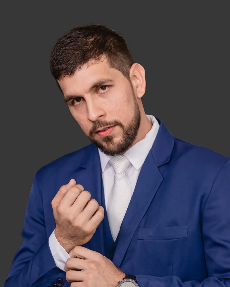 Jamario Pereira, de terno azul, olhando para a câmera